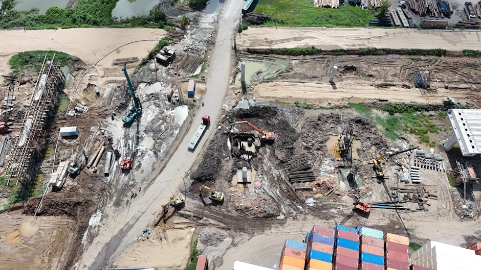 Aerial view of a busy construction site with heavy machinery and containers.