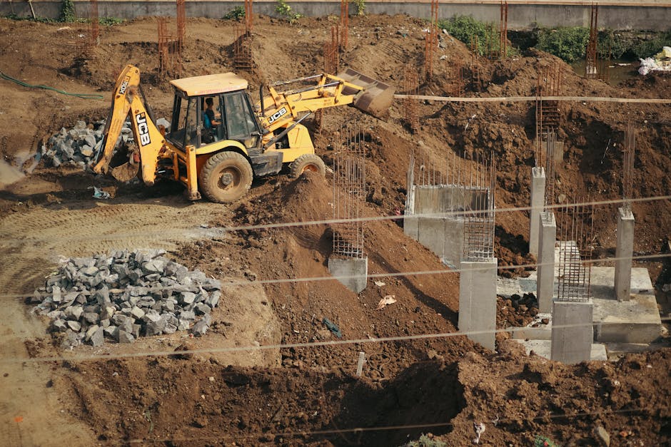 A bulldozer moves soil at a busy construction site.