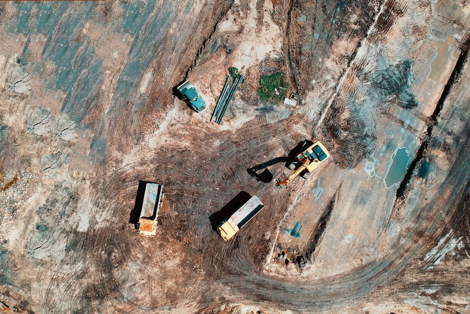 Aerial view of a construction site featuring trucks and excavation equipment.