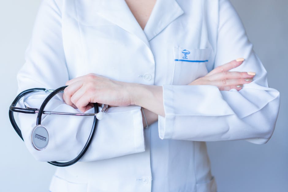 A close-up image of a doctor in a white coat with a stethoscope and arms crossed