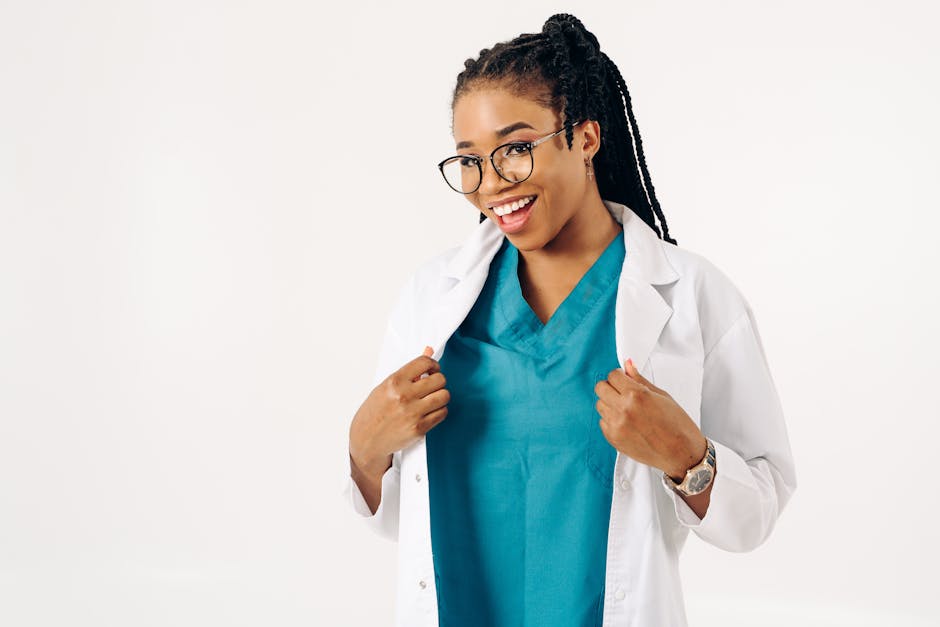Confident female doctor smiling in a white coat with teal scrubs