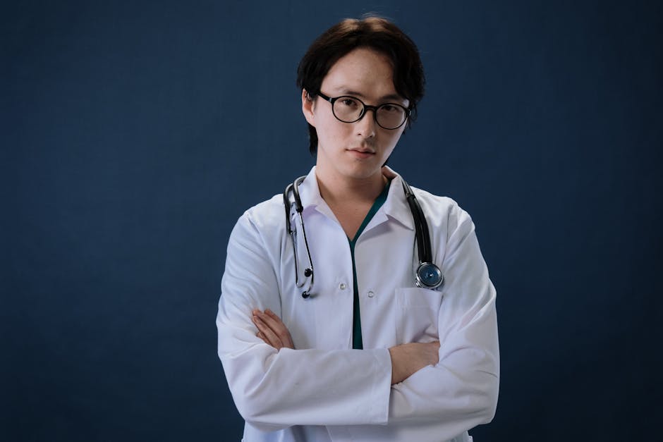 Portrait of a doctor with eyeglasses and stethoscope against a blue background in professional attire